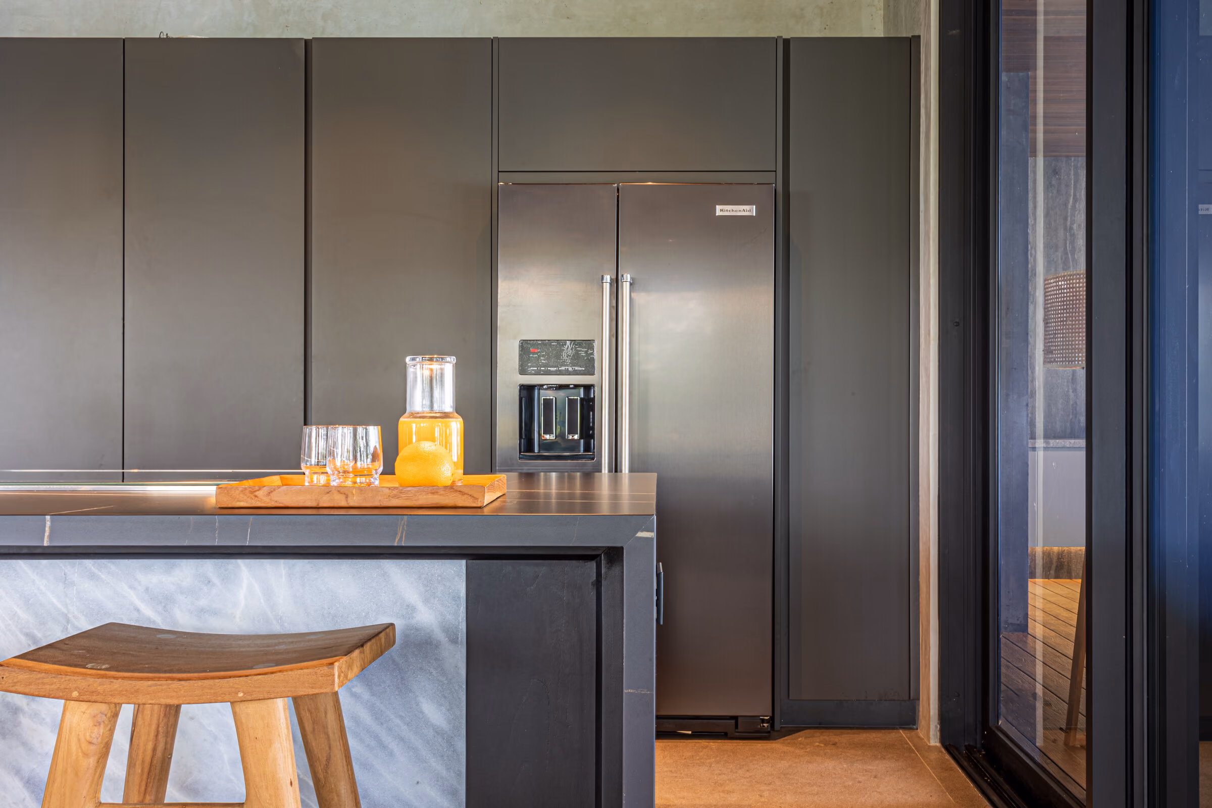 The kitchen seen from the dining area, opening to the terrace beyond.