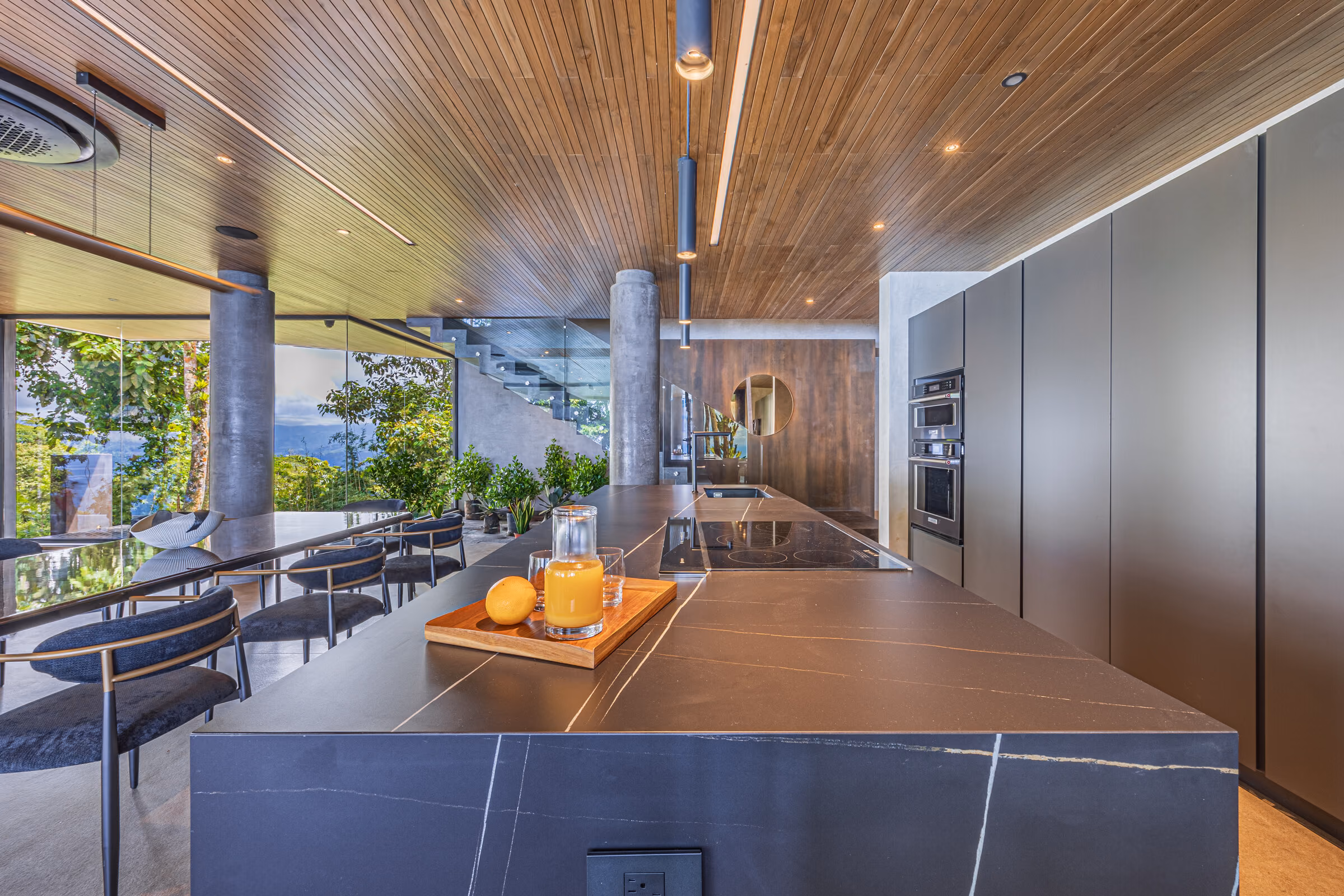 The kitchen island in porcelain with dark full-height cabinetry behind.